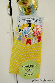 a yellow and white door handle with a happy may day tag hanging on it's side