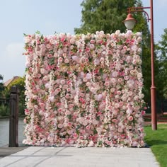 a large pink flowered wall next to a street light