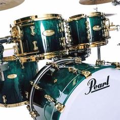 a green and gold drum set on top of a white background with the words pearl