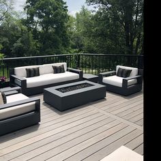 an outdoor patio with couches, tables and fire pit on the decking area