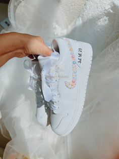 a person is holding up a white nike air force sneaker with flowers on it