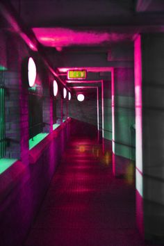 a long hallway with pink and green lights