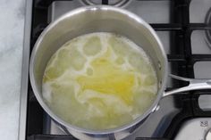 a pot filled with liquid sitting on top of a stove next to a burner