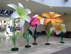 four glass vases with flowers in them on display