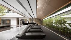 there is a row of treadmills in the gym with plants growing on the wall