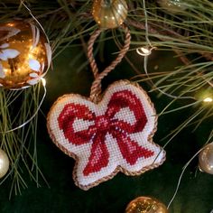 a cross stitch ornament hanging from a christmas tree