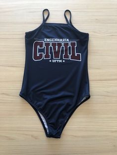 a women's swimsuit with the word civil printed on it, sitting on a wooden surface