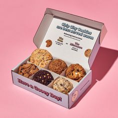 an open box of cookies on a pink background