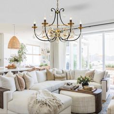 a living room filled with lots of furniture and pillows on top of a carpeted floor