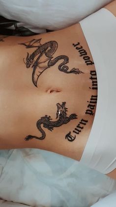 a woman's stomach with tattoos on it and the words dragon written in cursive writing