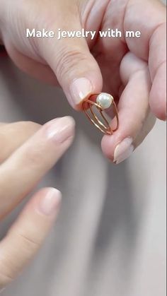 a woman holding onto a ring that is attached to her finger with the words make jewelry with me written on it