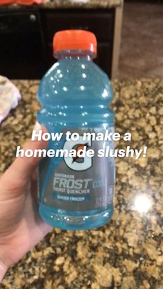 a hand holding a bottle of water on top of a counter