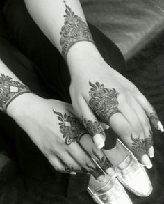 two hands with henna tattoos on them