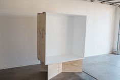 an empty white shelf sitting in the middle of a room