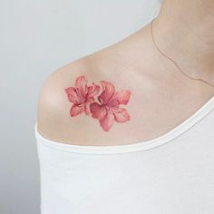 a woman with a pink flower tattoo on her shoulder