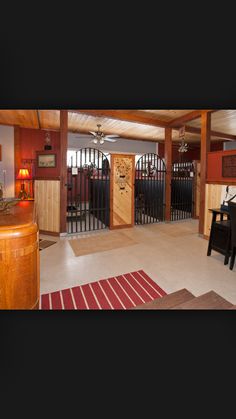 a living room filled with furniture next to a wooden table and black chairs on top of a hard wood floor