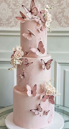 a three tiered pink cake with butterflies on it