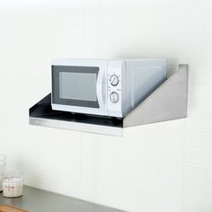 a microwave oven sitting on top of a shelf