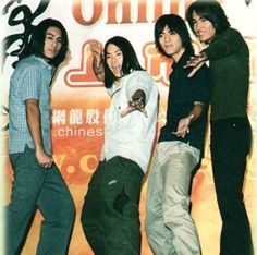 a group of young men standing next to each other in front of a chinese advertisement