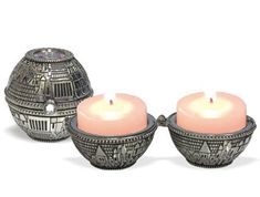 three candles sitting next to each other on top of a white surface with an intricate design