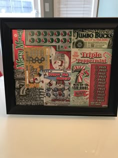 a framed poster with various items on it sitting on a white countertop in front of a window