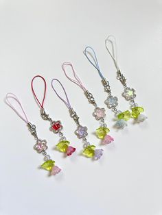 six different colored charms hanging from silver hooks