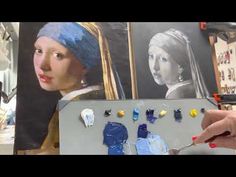 a woman holding a paintbrush in front of a painting of a girl with a pearl earring