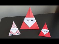 three origami santa hats on top of a black table next to each other