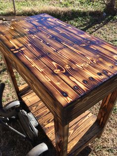 a wooden table sitting on top of a metal cart in the middle of a field