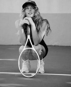 a black and white photo of a woman holding a tennis racket