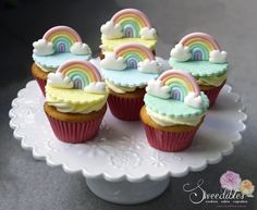 cupcakes with rainbow frosting on a cake plate