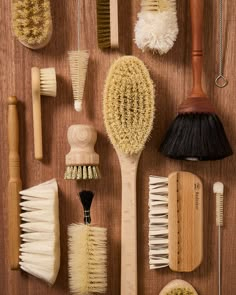 many different types of brushes on a wooden surface