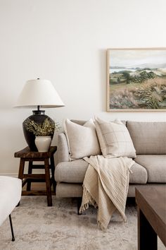 a living room filled with furniture and a painting on the wall above it's couch