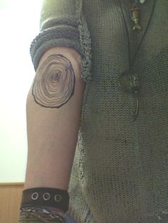 a woman's arm with a tattoo on it that looks like a spiral design