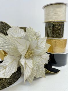 three spools of gold and white ribbon next to each other