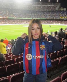 a woman standing in front of a soccer stadium