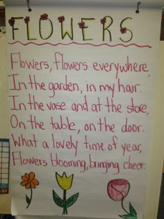 a sign with flowers written on it in front of a bulletin board that says flowers