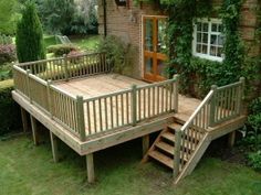 a wooden deck in front of a brick house