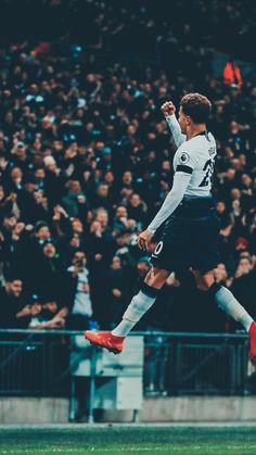 a soccer player is jumping up in the air to celebrate his team's victory