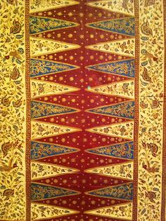 an intricately designed rug with blue, red and gold accents on it's edges