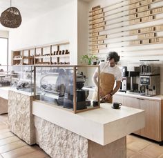 a woman standing behind a counter in a coffee shop