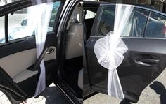 an open car door with a bow tied to it's front and side doors