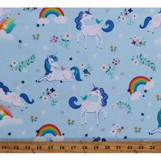 a blue fabric with unicorns and stars on it, in front of a ruler