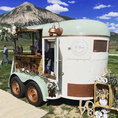 an old fashioned food truck is decorated with flowers and greenery