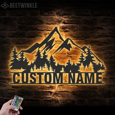 a person holding a remote control in front of a brick wall with the word custom name on it