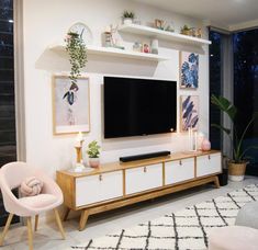 a living room filled with furniture and a flat screen tv on top of a wooden entertainment center