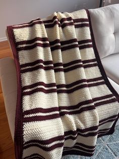 a white couch with a striped blanket on it