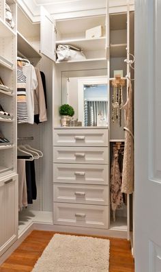 an organized closet with white drawers and shelves