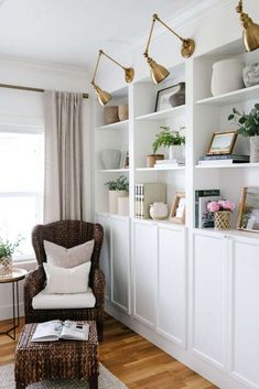 a living room filled with furniture and bookshelves next to a window on top of a hard wood floor