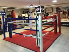 a boxing ring with red, white and blue ropes on the floor in a gym